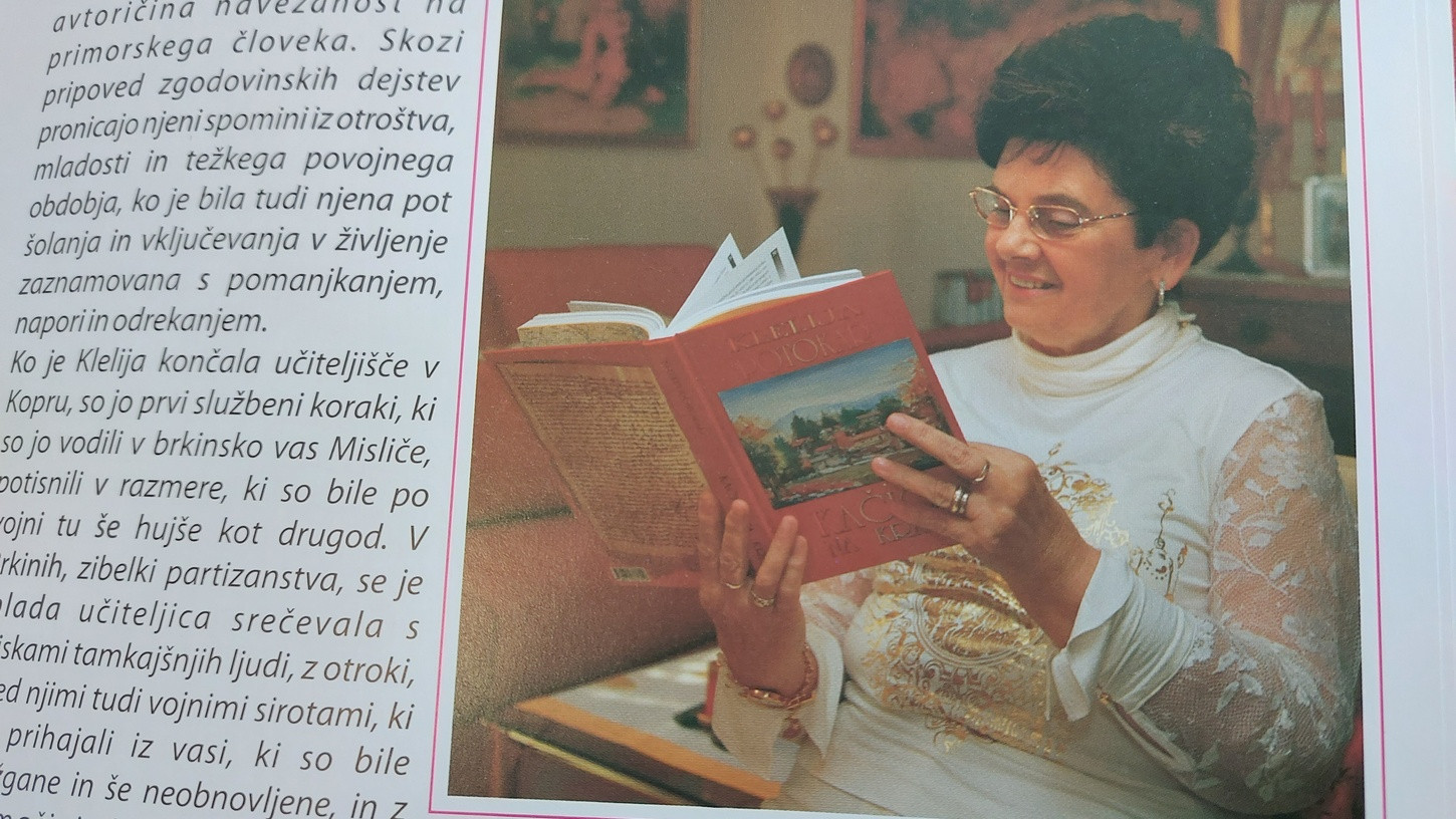 Klelija Potokar drži v rokah monografijo o Vremski dolini, svojo drugo obsežno knjigo o rojstnih krajih. Fotografija je objavljena na zadnjih straneh omenjene knjige.