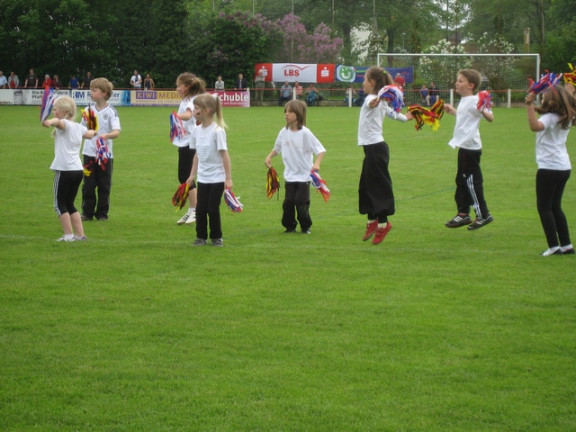 Trakovi v barvah slovenske in nemške zastave v rokah otrok