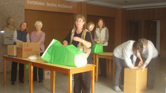 Članice zveze slovenskih mater in žena pri pripravi paketov z nepokvarljivo hrano