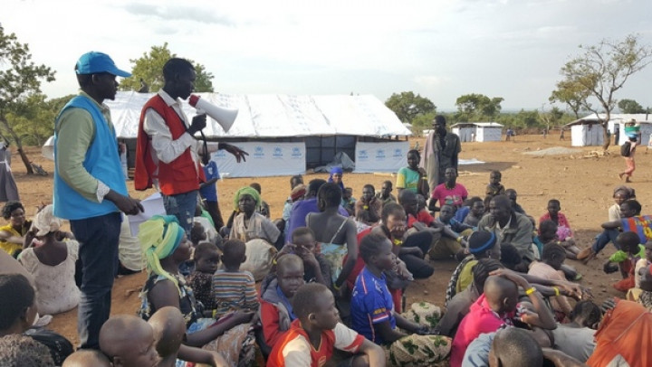 Južnosudanski begunci, ki so prispeli v Ugando, poslušajo navodila pristojnih v sprejemnem centru taborišča Bidibidi