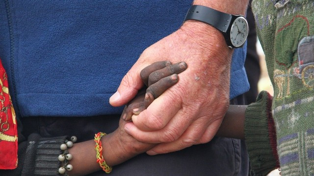 Roka smetiščarskega otroka v roki Petra Opeke (foto: Izidor Šček)