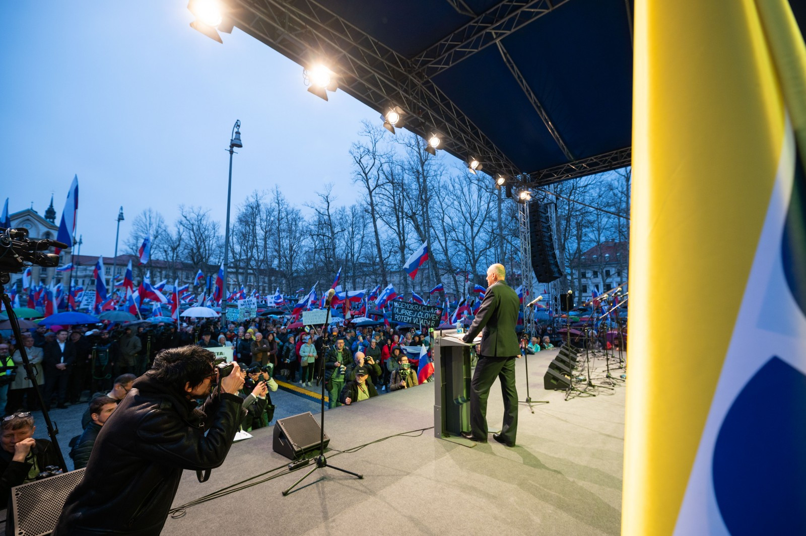 Janez Jnaša med nagovorom zbranim protestnikom, ki so na shod prišli s številnimi zastavami in transparenti.