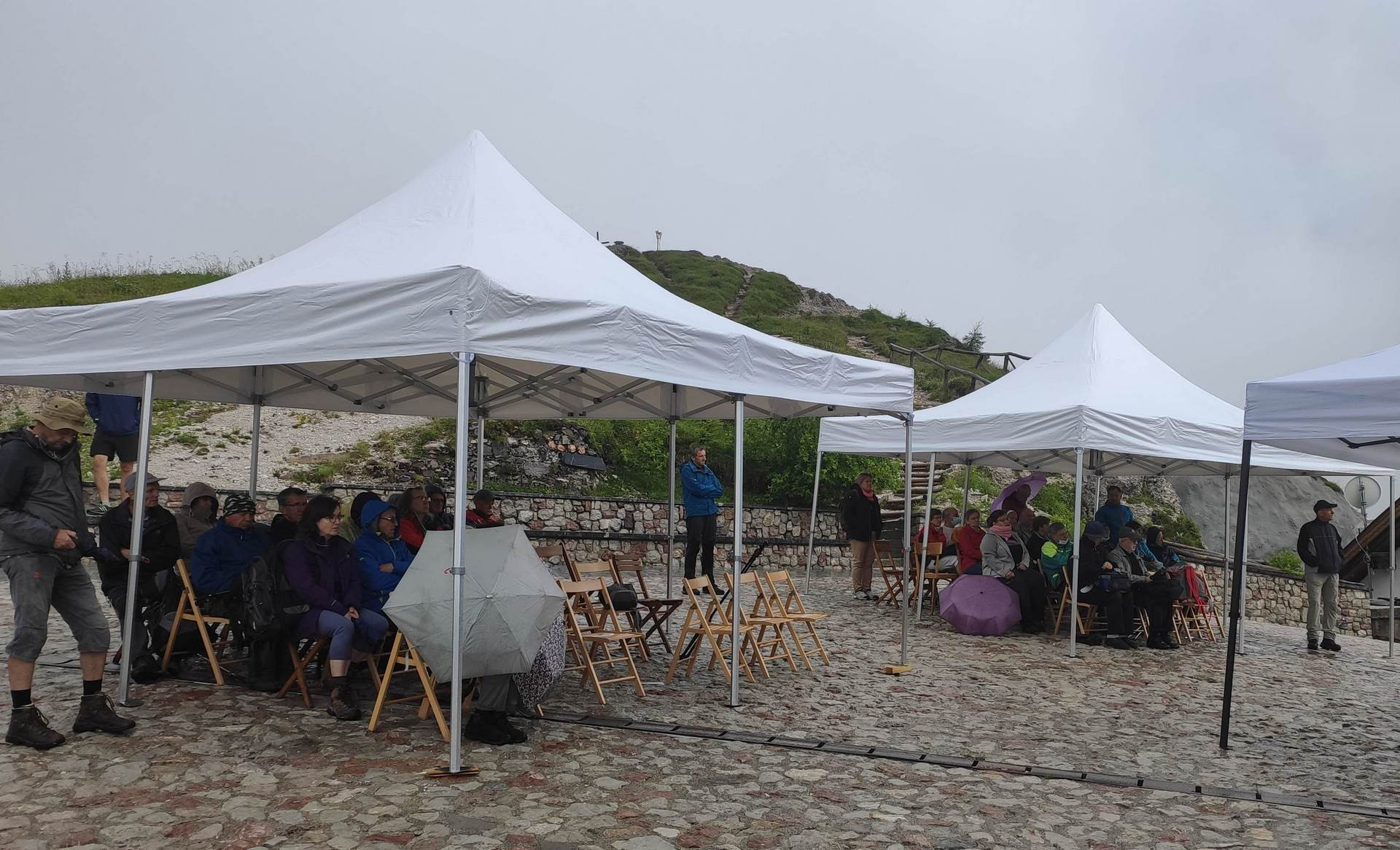 Udeleženci na ploščadi za cerkvijo poslušajo predavatelja iz doline