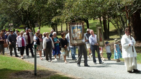 Rojaki v procesiji z banderoma