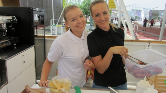 Dekleti pri strežbi slovenskih tradicionalnih jedi na Expu