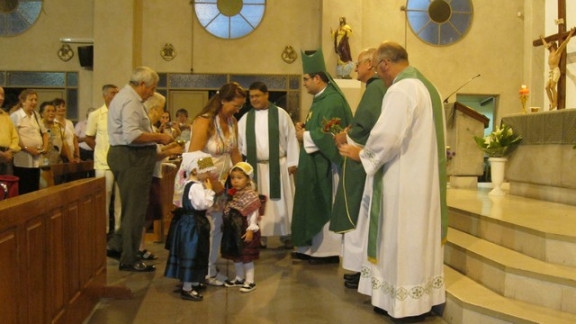 Deklice v slovenskih narodnih nošah so podarile novemu župniku šopek