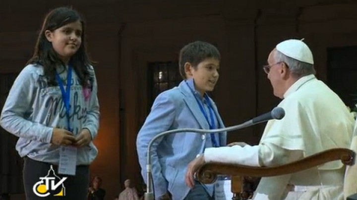 Papež Frančišek med srečanjem z otrokom, ki mu je izročil pismo