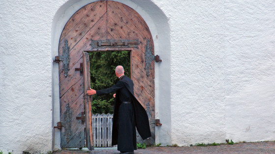 Duhovnik pred vrati samostana (photo: Pixabay)