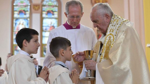 Papež podeljuje prvo obhajilo otrokom (foto: Vatican News)