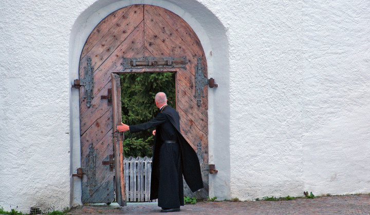 Duhovnik pred vrati samostana (foto: Pixabay)